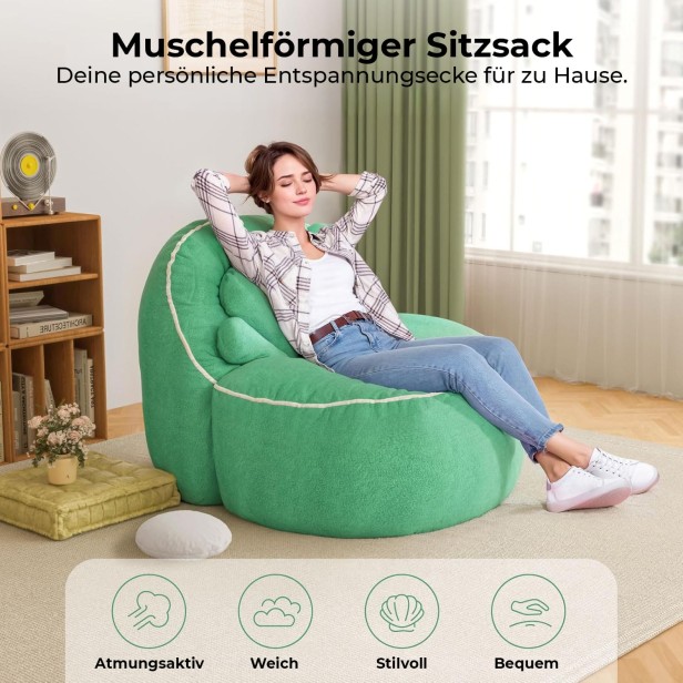 Eine Frau sitzt entspannt auf einem großen, grünen, weichen Pouf oder Sitzsack, der die Form einer Muschel hat.