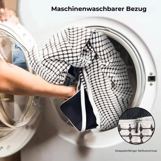 Eine Person legt einen Haustierbettbezug (mit schwarz-weißem Muster) in die Waschmaschine, um zu veranschaulichen, dass der Bezug maschinenwaschbar ist.