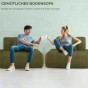 Ein junges Paar sitzt auf zwei Elementen eines bequemen olivgrünen Sofas und stößt mit Tassen an. Das Foto vermittelt Stil und Gemütlichkeit unter Freunden.