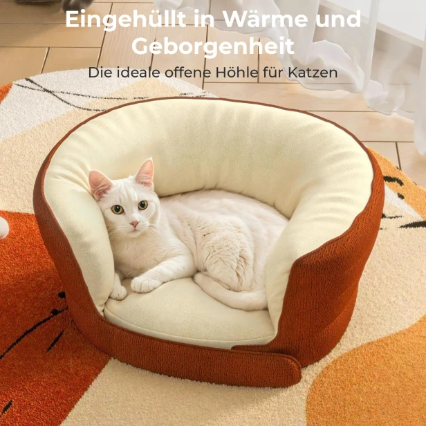 Die weiße Katze liegt gemütlich in einem weichen, terrakottafarbenen und beigen Bett mit hohem Rand.