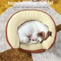 Der kleine Hund schläft zusammengerollt und versteckt sich in einer Spalte eines weichen, runden Bettes mit hohen Seitenwänden.