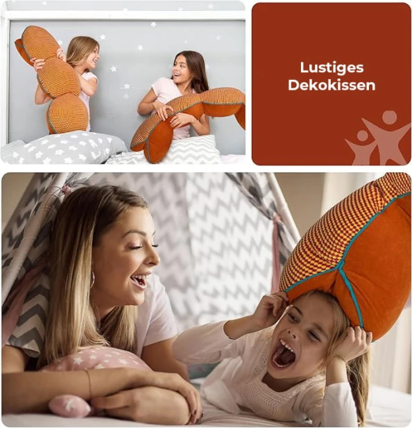 Zwei lächelnde Personen spielen in einem Zimmer auf Betten mit gemusterter Bettwäsche mit Kissen in Schlangenform.