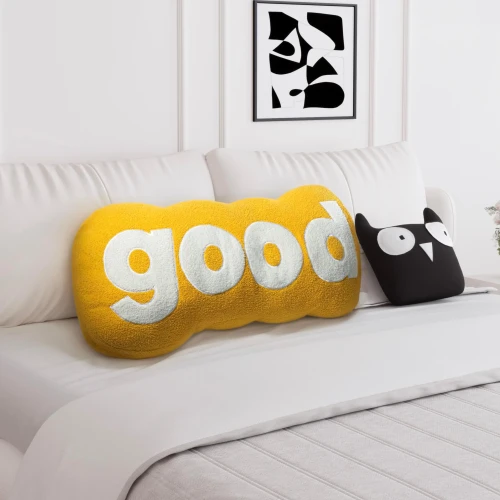 Plüschiges gelbes Lesekissen. Schlafzimmer-Arrangement auf dem Bett.