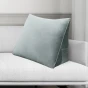 Vor dem Hintergrund des Wohnzimmersofas ist ein graues Rückenstützkissen zu erkennen.